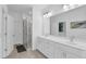 Bathroom featuring double vanity, glass enclosed shower, and a large mirror over the vanity at 3508 Mount Blue Ave, Tucker, GA 30084