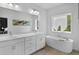 Bathroom featuring double vanity, soaking tub, and a large window allowing for lots of natural light at 3508 Mount Blue Ave, Tucker, GA 30084