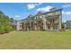 Rear exterior shot of townhomes highlighting decks and a large grassy area at 3508 Mount Blue Ave, Tucker, GA 30084