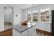 Kitchen island featuring granite countertops, white cabinets, stainless appliances and hardwood floors at 3508 Mount Blue Ave, Tucker, GA 30084