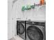 Modern laundry room with front loading washer and dryer, overhead storage shelf with cleaning supplies at 3508 Mount Blue Ave, Tucker, GA 30084