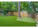 Backyard featuring artificial turf, putting green, and mature trees, great for outdoor activities at 480 Wimbledon Ne Rd, Atlanta, GA 30324
