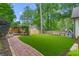 Backyard with manicured artificial turf, brick walkway, fire pit and mature trees at 480 Wimbledon Ne Rd, Atlanta, GA 30324