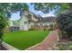 Manicured backyard featuring artificial turf, a brick pathway, and a wooden deck off of the house at 480 Wimbledon Ne Rd, Atlanta, GA 30324
