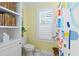 Bright bathroom featuring a toilet, plantation shutters, decorative shower curtain and built-in shelving at 480 Wimbledon Ne Rd, Atlanta, GA 30324