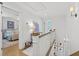 Bright hallway with white wooden railing, hardwood floors, and decorative lighting fixtures at 480 Wimbledon Ne Rd, Atlanta, GA 30324