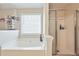 Bright bathroom featuring a large soaking tub and a separate glass-enclosed shower at 4920 Markim Forest Ln, Sugar Hill, GA 30518