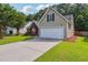 Charming home featuring a well-manicured lawn, a two-car garage and a cozy brick facade at 4920 Markim Forest Ln, Sugar Hill, GA 30518