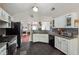 Well-lit kitchen with granite countertops, stainless steel appliances, and dark tile flooring at 4920 Markim Forest Ln, Sugar Hill, GA 30518