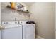 Functional laundry room with washer, dryer, and wire shelving above at 4920 Markim Forest Ln, Sugar Hill, GA 30518