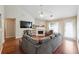 Cozy living room with wood floors, a fireplace, and a large sectional sofa at 4920 Markim Forest Ln, Sugar Hill, GA 30518