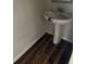 Functional half-bathroom with a pedestal sink, wood-look flooring and fresh, white paint on the walls at 1900 Old Dogwood, Jonesboro, GA 30238
