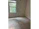 Simple bedroom featuring plush carpeting, a window overlooking a verdant landscape, and white walls at 1900 Old Dogwood, Jonesboro, GA 30238