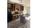 Spacious kitchen featuring dark wood cabinets, stainless steel appliances, and an island with a granite countertop at 1900 Old Dogwood, Jonesboro, GA 30238