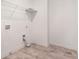 Well-lit laundry room with white walls, grey tile floor, and convenient shelving at 939 Brittfield Way, Loganville, GA 30052