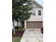 Townhouse featuring well-maintained landscaping, a two-car garage, and a brick facade at 3192 Spicy Cedar Lane Ln, Stonecrest, GA 30038
