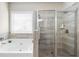 Modern bathroom featuring bathtub with tile surround and glass shower at 850 Ethereow Ct, Lawrenceville, GA 30046