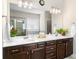 Bright bathroom featuring long counter with dual sinks and dark wood cabinets at 850 Ethereow Ct, Lawrenceville, GA 30046