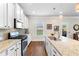 Bright kitchen with white cabinetry, granite countertops, stainless appliances, and hardwood floors at 850 Ethereow Ct, Lawrenceville, GA 30046