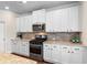 Modern kitchen features white cabinets, granite countertops, and stainless steel appliances at 850 Ethereow Ct, Lawrenceville, GA 30046