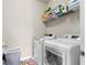 Laundry room with white washer and dryer, storage shelf, and functional layout at 850 Ethereow Ct, Lawrenceville, GA 30046