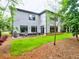 Backyard patio with modern seating and a grill, surrounded by green grass and mature trees at 913 Sunny Meadows Ln, Marietta, GA 30062