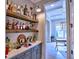 Stylish bar area with open shelving, a countertop, and cabinetry, with an adjacent room visible through a doorway at 913 Sunny Meadows Ln, Marietta, GA 30062