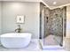 Freestanding tub and glass-enclosed shower featuring elegant tile work at 913 Sunny Meadows Ln, Marietta, GA 30062