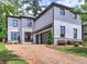 Charming two-story home with a brick driveway and a combination of white painted brick and stone facade at 913 Sunny Meadows Ln, Marietta, GA 30062