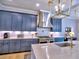 Well-lit kitchen with a stainless steel hood vent and blue cabinetry at 913 Sunny Meadows Ln, Marietta, GA 30062