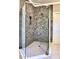 A glass-enclosed shower with hexagonal tile walls and herringbone floor at 913 Sunny Meadows Ln, Marietta, GA 30062