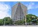 Tall building featuring a gray facade, surrounded by greenery, blue skies and street-level cars at 120 Ralph Mcgill Ne Blvd # 1409, Atlanta, GA 30308