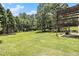 Expansive backyard with mature trees, a deck, and a basketball hoop at 317 Saint Pauls Ct, Stockbridge, GA 30281