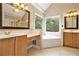 Bathroom with double vanity, soaking tub, and large windows with wooded views at 317 Saint Pauls Ct, Stockbridge, GA 30281