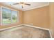 Comfortable bedroom with large window, ceiling fan, and neutral carpet at 317 Saint Pauls Ct, Stockbridge, GA 30281