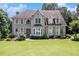 Charming two-story home with stone facade, mature trees, and well-manicured lawn at 317 Saint Pauls Ct, Stockbridge, GA 30281