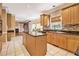Spacious kitchen with central island, tiled floor, light wood cabinets and contrasting backsplash at 317 Saint Pauls Ct, Stockbridge, GA 30281