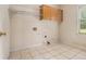 Laundry room with tile flooring, shelving, and natural light from a window at 317 Saint Pauls Ct, Stockbridge, GA 30281