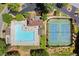 Aerial view of community pool, tennis courts, clubhouse, green spaces, and tree lined streets at 4300 May Apple Dr, Alpharetta, GA 30005