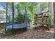 Backyard view featuring a trampoline and a raised deck for outdoor activities and enjoyment at 4300 May Apple Dr, Alpharetta, GA 30005