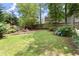 Lush backyard features a well-maintained lawn, mature trees, and a stone fire pit area, perfect for relaxing outdoors at 4300 May Apple Dr, Alpharetta, GA 30005