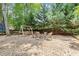 Landscaped backyard features a stone area with a swing, chairs, and a fire pit, perfect for outdoor gatherings at 4300 May Apple Dr, Alpharetta, GA 30005