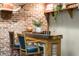 Rustic bar with brick wall, wooden countertop, and comfortable seating for entertaining guests at 4300 May Apple Dr, Alpharetta, GA 30005