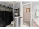 Modern bathroom with black shower curtain and rustic shelving for stylish storage solutions at 4300 May Apple Dr, Alpharetta, GA 30005