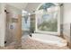 Bathroom featuring a soaking tub, tiled shower, and large windows at 4300 May Apple Dr, Alpharetta, GA 30005