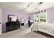 Bedroom with bright purple walls, neutral carpet, and large windows providing ample natural light at 4300 May Apple Dr, Alpharetta, GA 30005
