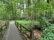 Community walking bridge that crosses a small creek surrounded by lush greenery at 4300 May Apple Dr, Alpharetta, GA 30005
