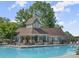Exterior shot of the clubhouse building by the pool with outdoor seating and umbrellas at 4300 May Apple Dr, Alpharetta, GA 30005