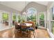 Sunny dining area with large windows, chandelier, views of wooded lot, and access to outdoor dining at 4300 May Apple Dr, Alpharetta, GA 30005