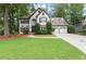 Inviting two-story home with a three-car garage, lush lawn, and mature trees, offering curb appeal at 4300 May Apple Dr, Alpharetta, GA 30005